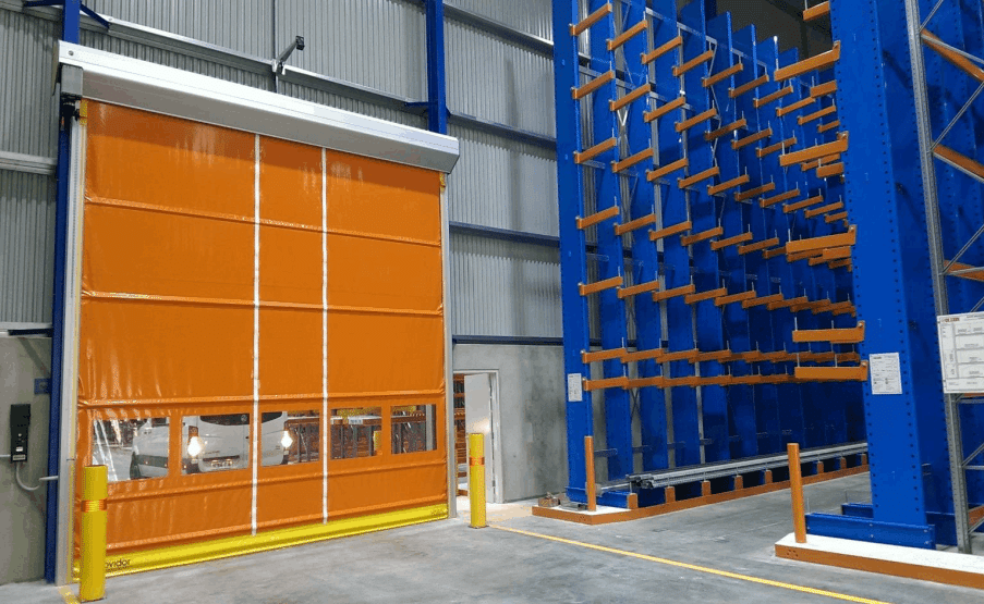 High-speed orange roller door next to blue cantilever racks in a clean warehouse setting.