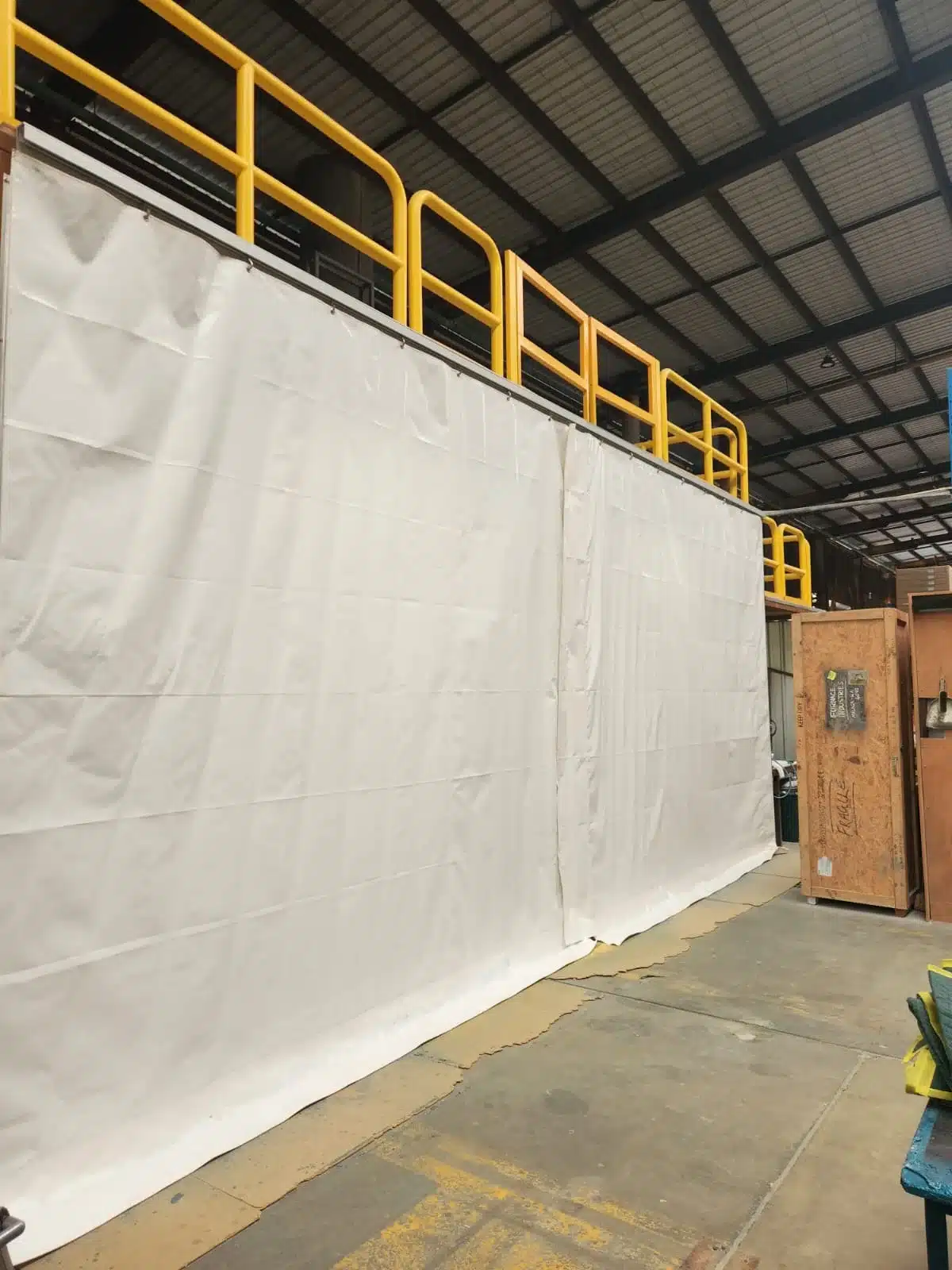 White industrial curtain wall with yellow safety railings