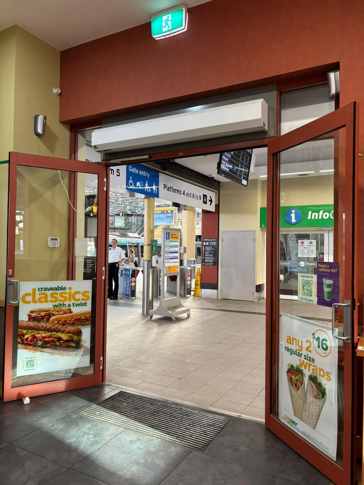 Commercial air curtain unit mounted above open glass double doors at a retail entrance to maintain indoor climate control.